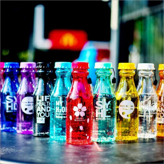 a row of different colored bottles on a table 