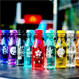 a row of different colored bottles on a table 