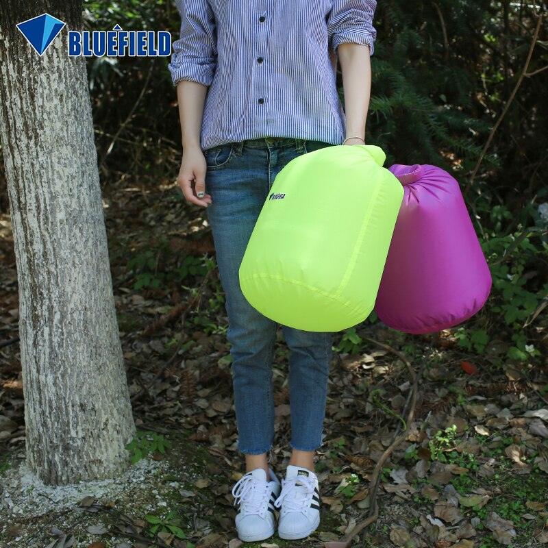 a person holding a pink suitcase standing next to a tree 